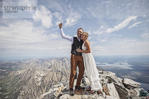 Neuvermähltes Brautpaar feiert nach der Heirat auf dem Berg