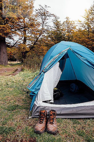 Campingzelt und Trekkingschuhe im Herbstwald