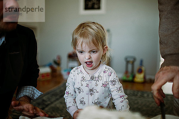Kleinkind macht albernes Gesicht mit Eiscreme auf der Nase
