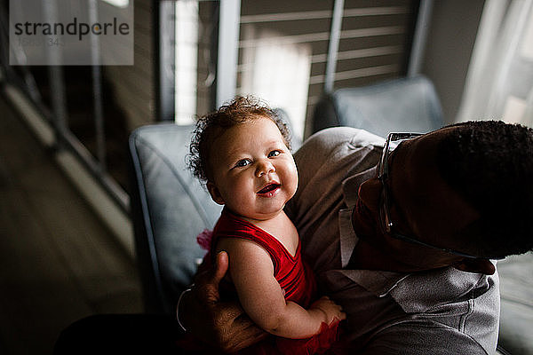 Zweirassiges Baby lächelt für die Kamera  wenn der Vater eines Afroamerikaners lächelt