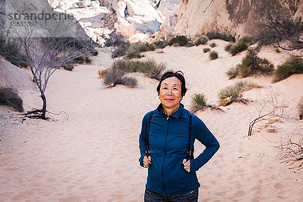 Ältere asiatische Frau wandert in der Wüstenlandschaft