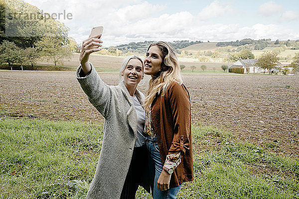 Zwei Freundinnen beim Selfie in einer französischen Landschaft auf dem Land