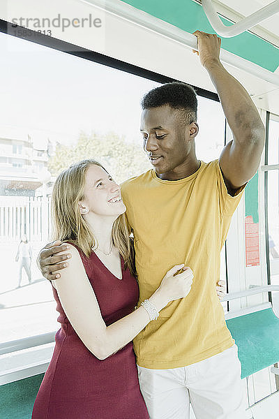 Jungen und Mädchen sehen sich im Bus an und lachen