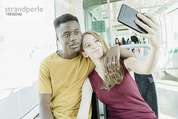 Verliebter Junge und verliebtes Mädchen nehmen einen Selfie im Bus