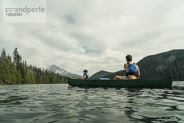 Ein junges Mädchen fährt mit ihrem Vater in einem Kanu auf dem Lost Lake in Oregon.