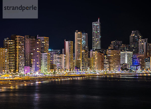 Die nächtliche Skyline von Benidorm mit vielen Lichtern der Wolkenkratzer  die den Strand  die Küste und das Mittelmeer beleuchten  wenn sie an der Küste ankommen. Horizontales Bild