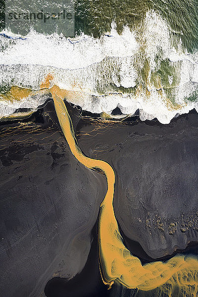 Luftaufnahme des geflochtenen orangenen Flusses  der im Süden in den Ozean mündet