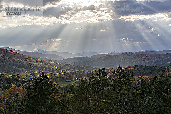 Sonnenlicht strahlt durch Wolken über den Bergen in Quechee  Vermont.