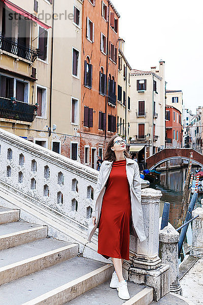 junger Tourist in Kleid und Mantel auf den Straßen von Venedig