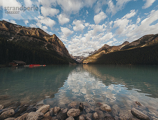 Ufer des Lake Louise mit Bootshaus und Bergen in der Ferne.