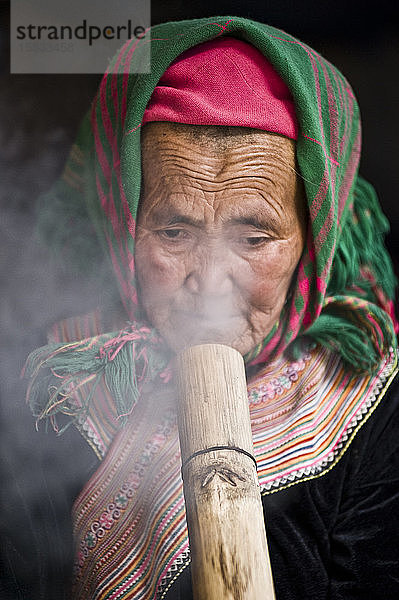 Alte Dame raucht Thuoc Lao  ein traditioneller vietnamesischer Brauch