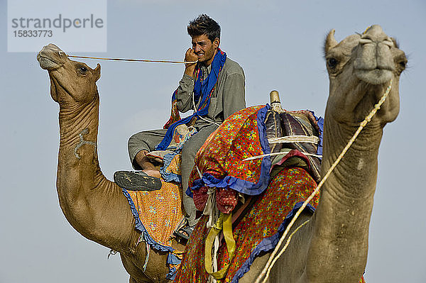 Rajasthani auf einem Kamel sitzend in der Wüste Thar