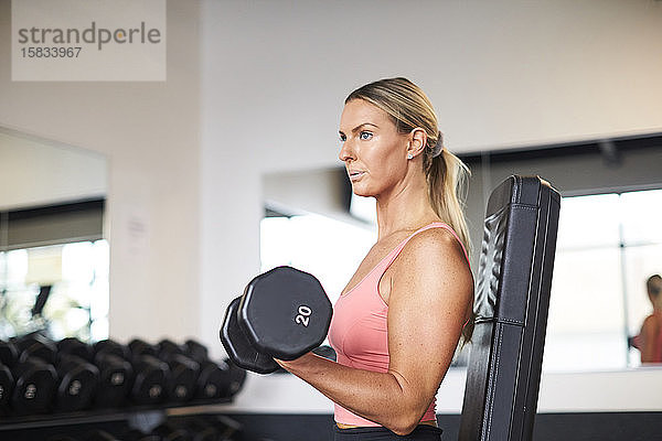 Eine Frau beim Krafttraining im Fitnessstudio.