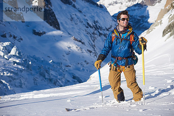 Lächelnder Skifahrer in blauer Jacke blieb bei einer Gletscherabfahrt stehen