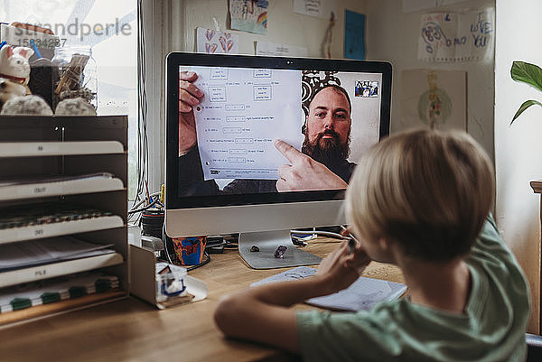 Blick hinter die Kulissen eines Jungen im Schulalter  der von einem Lehrer lernt  der den Unterricht leitet