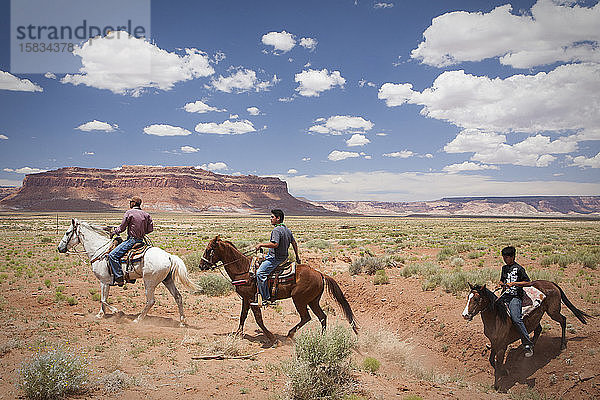 Reiter durchqueren eine Ebene in der Nähe des Monument Valley  Arizona