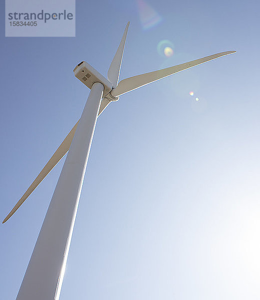 Windturbine gegen blauen Himmel mit Sonneneruption