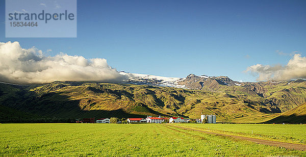 Felder und Bauernhaus unter dem Vulkan Eyjafjallajokull in Island