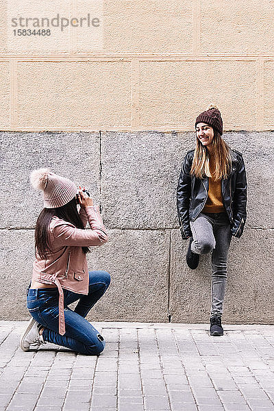 Schönes lesbisches Paar beim Fotografieren auf der Straße. LGBT-Konzept.