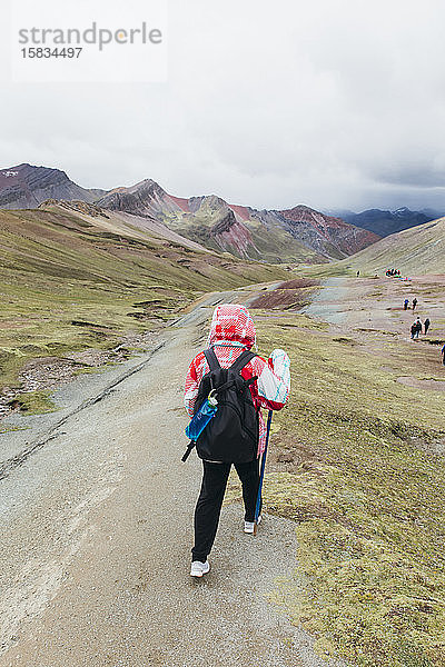 Eine junge Frau wandert auf den berühmten Regenbogenberg in Peru