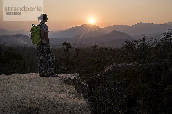 Silhouette einer jungen Wanderin beim Betrachten des Sonnenuntergangs am Pai Canyon (Kong Lan)  Nordthailand.