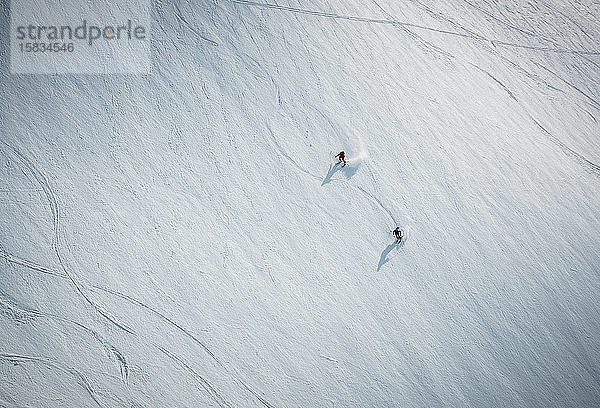 Zwei Männer beim Skifahren auf Schnee in Island aus dem Überkopfwinkel