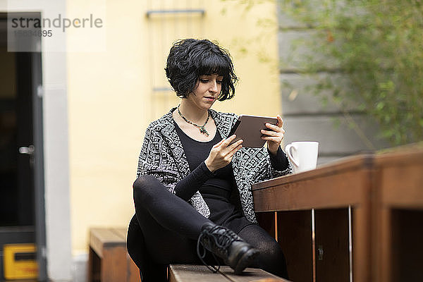 junge Frau mit Laptop im Freien bei der Arbeit