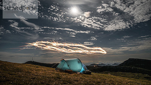 Feuerwerk über dem nächtlichen Campingzelt in den Karpaten