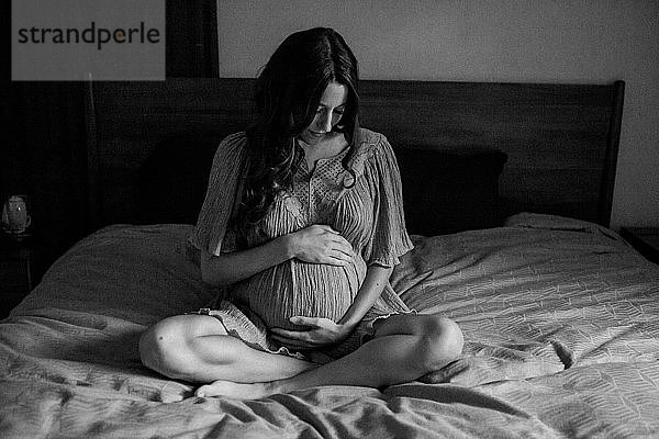 Schwangere Frau im Bett schwarz-weiß