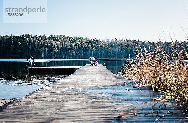 Großvater bringt seiner Enkelin das Angeln in einem See in Schweden bei