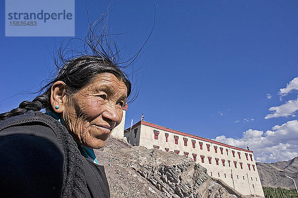 Buddhistische Dame an einem windigen Tag in der Nähe eines Klosters
