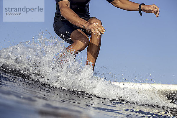 Beine eines Surfers auf einer Welle