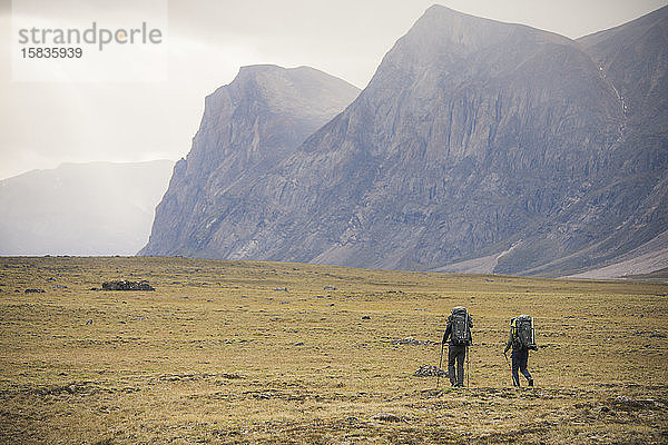 Rückansicht von zwei Rucksacktouristen beim Wandern am Akshayak-Pass  Kanada.