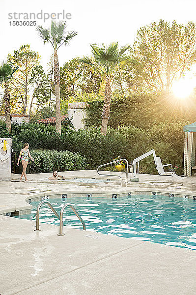 Mann und Kind entspannen sich an einem sonnigen Abend am Pool in Arizona