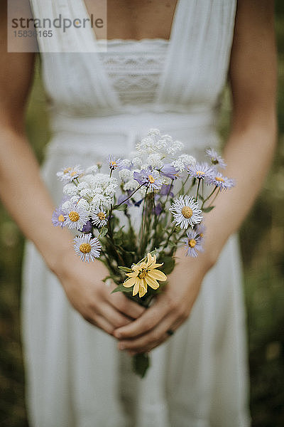 Nahaufnahme der Braut mit dem Brautstrauss aus Wildblumen