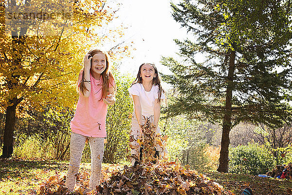 Zwei junge Mädchen spielen im Herbst draußen