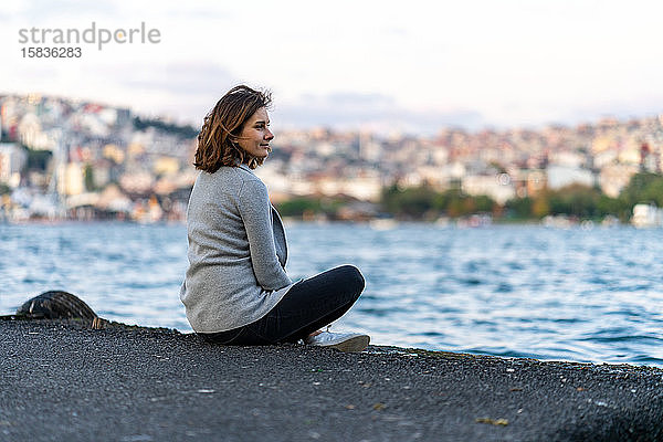 Junge Frau betrachtet Istanbuler Hügel über dem Goldenen Horn