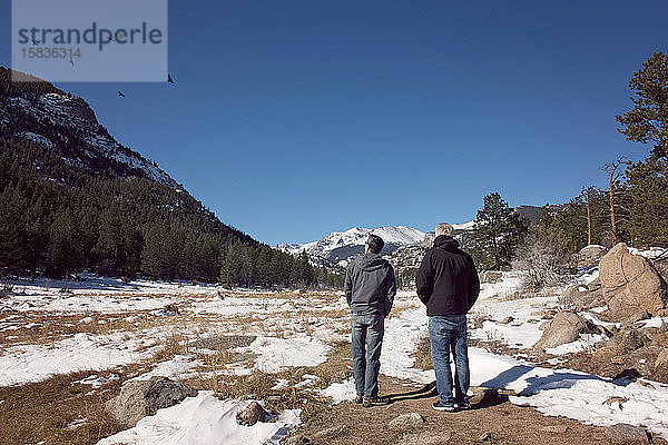 Zwei Männer beobachten an einem sonnigen Tag Vögel in den Rocky Mountains