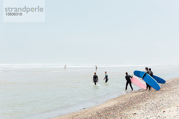 Surfer machen sich auf den Weg zu einem Surfcamp