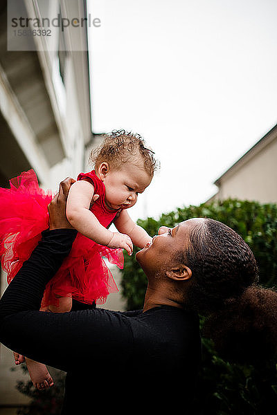 Afroamerikanische Stiefschwester hält bi-rassische Baby-Schwester