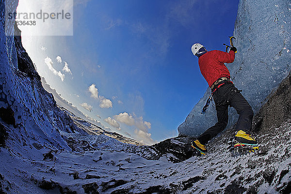 reifer Mann klettert am Solheimajokull in Südisland