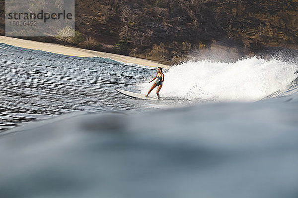 Junge Frau beim Surfen im Indischen Ozean