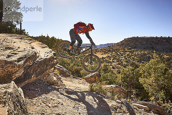 Ein Mountainbiker überspringt einen kleinen Tropfen auf der Strecke in Colorado.