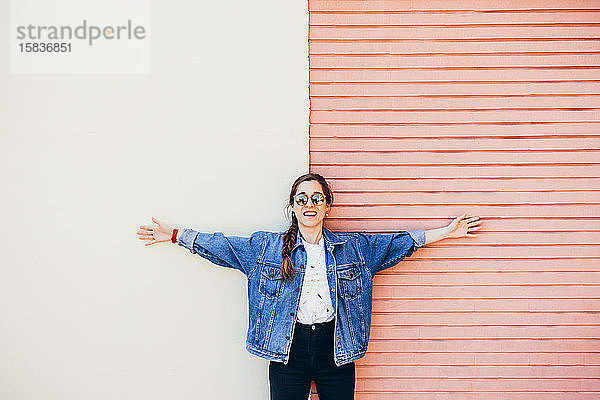 Attraktive junge Frau  die an einer zweifarbigen Wand lacht