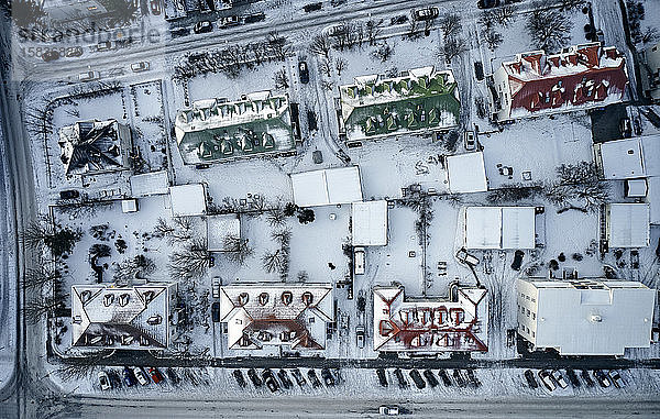 Draufliegende Drohnenansicht der schneebedeckten Gebäude im Bezirk