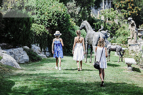 Drei gehende Mädchen und eine Pferdestatue