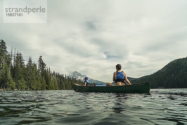 Ein junges Mädchen fährt mit ihrem Vater in einem Kanu auf dem Lost Lake in Oregon.