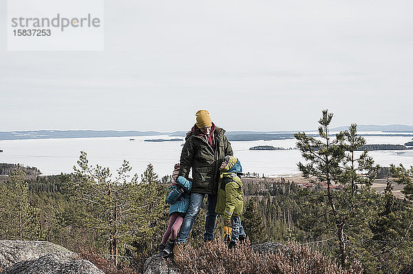 Vater und seine Kinder genießen das gemeinsame Wandern und den Blick aufs Meer