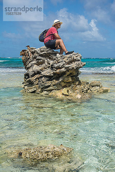 Mann auf einer Felsformation sitzend