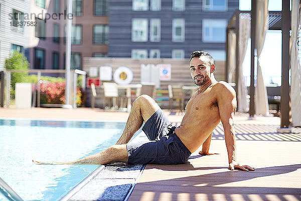 Ein fitter Mann entspannt sich am Pool.